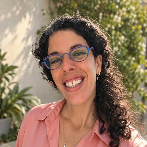 מיכל משי אסיאס מצולמת בחוץ, בגינה מוארת